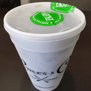 a white cup with a green sticker on it