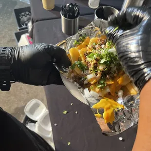 Papa fritas con asada, queso, birria, cilantro, cebolla y salsa.