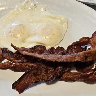 Bacon and eggs over easy. The bacon is very flavorful and delicate, not too chewy.