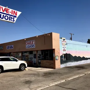 a car parked in front of a drive - in liquor store