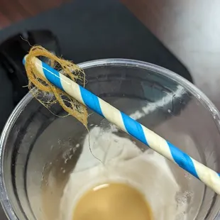 a cup of coffee with a blue and white striped straw