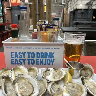 a tray of oysters and a glass of beer