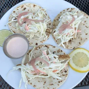 Grilled mahi mahi tacos, spicy crema sauce on the side.