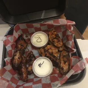 a basket of chicken wings and dips