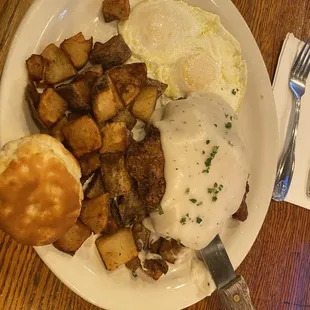 Chicken Fried Steak with over easy eggs home fries and a biscuit