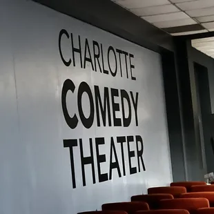 rows of chairs in front of a sign