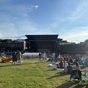 a crowd of people sitting on the grass