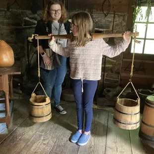 Demonstrating an eight year old child carrying heavy water to supply the household
