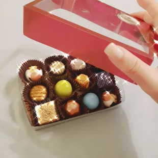 a hand holding a box of chocolates