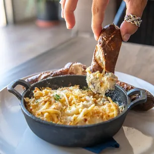 a person dipping something into a skillet