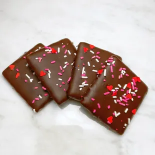 four pieces of chocolate covered with sprinkles