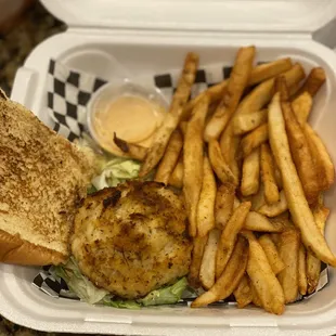 a sandwich and fries in a styrofoam container