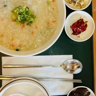 a bowl of soup and spoons on a tray
