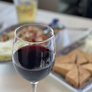 a glass of red wine and crackers