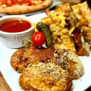 a plate of food with a side of pizza