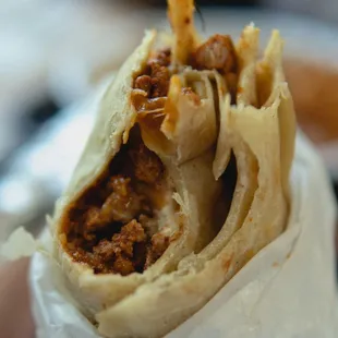 a hand holding a burrito