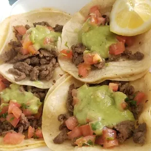 four tacoss in a styrofoam container