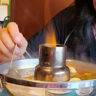 a woman stirring a pot of soup