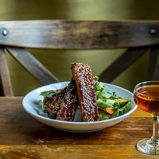 a plate of meat and a glass of wine