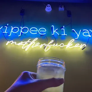 a hand holding a mason jar with a drink in it