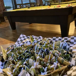 a plate of nachos and a pool table