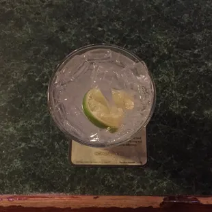 a glass of water with a slice of lime in it