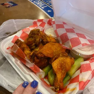 a tray of chicken wings and celery