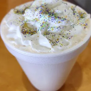 a cup of coffee with whipped cream and sprinkles