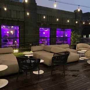 a rooftop lounge area with purple lighting