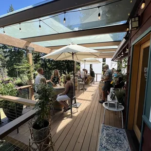 a group of people sitting on a deck under umbrellas