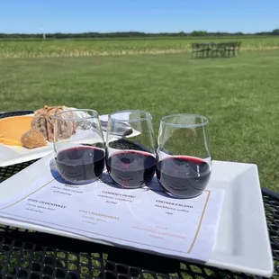 three glasses of red wine and a cheese board