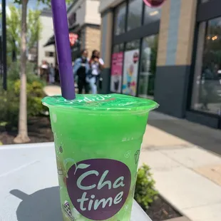 a green cup with a purple straw