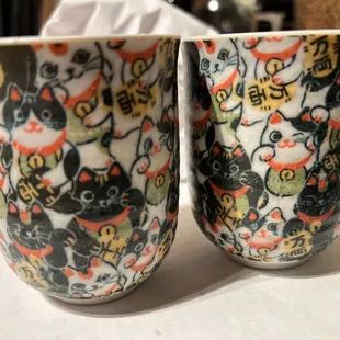 two cups with a cat design on them