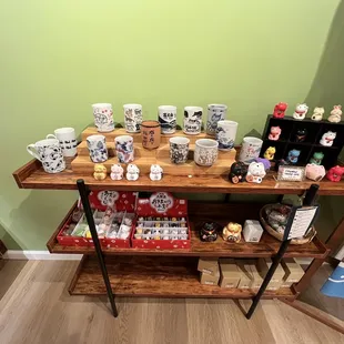 a shelf of coffee mugs and other items