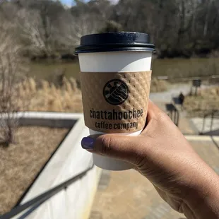 a hand holding a coffee cup