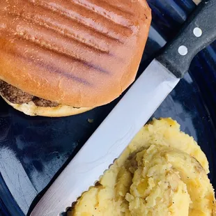 a hamburger and mashed potatoes on a plate
