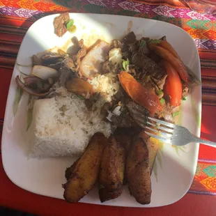 Lomo Saltado meal with beef, rice, tomatoes and red onion with great plantains.