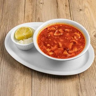 a bowl of chili with a lime wedge