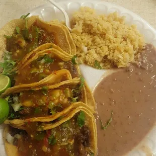4 tacos de carne asada with a side of arroz con frijoles