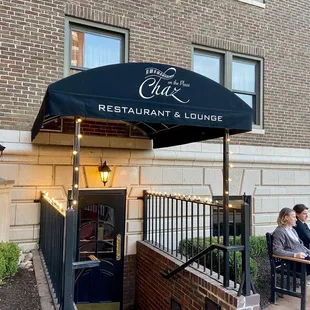 people sitting outside of a restaurant