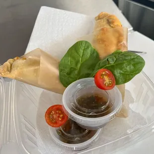 a sandwich and dipping sauce in a plastic container