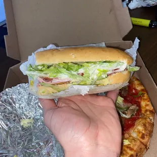 a hand holding a sandwich