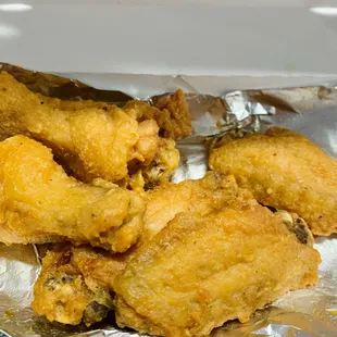 a pile of fried chicken on tin foil
