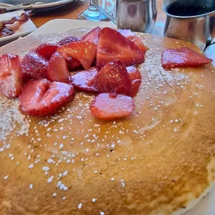 Big old fluffy buttermilk pancakes covered with strawberries