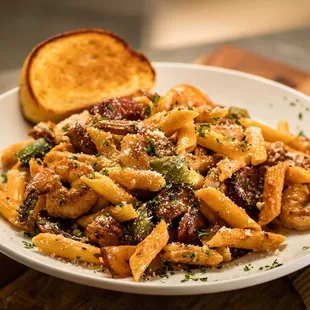 New Orleans Pasta: Shrimp, chicken, smoked sausage, peppers, onions &amp; penne pasta in a spicy homemade cajun alfredo sauce with garlic bread