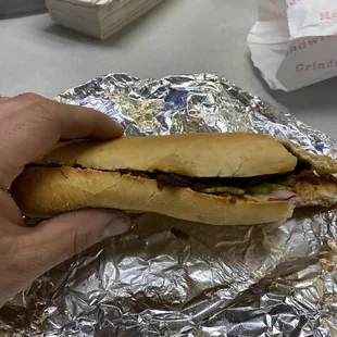 a hand holding a sandwich