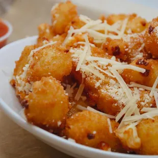 a plate of tater tots with parmesan cheese