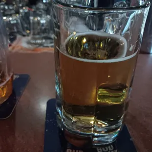 a glass of beer on a coaster