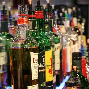 a row of liquor bottles on a bar