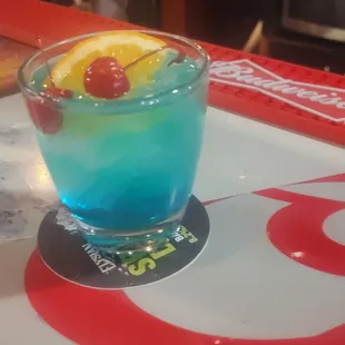 a blue drink with a cherry garnish